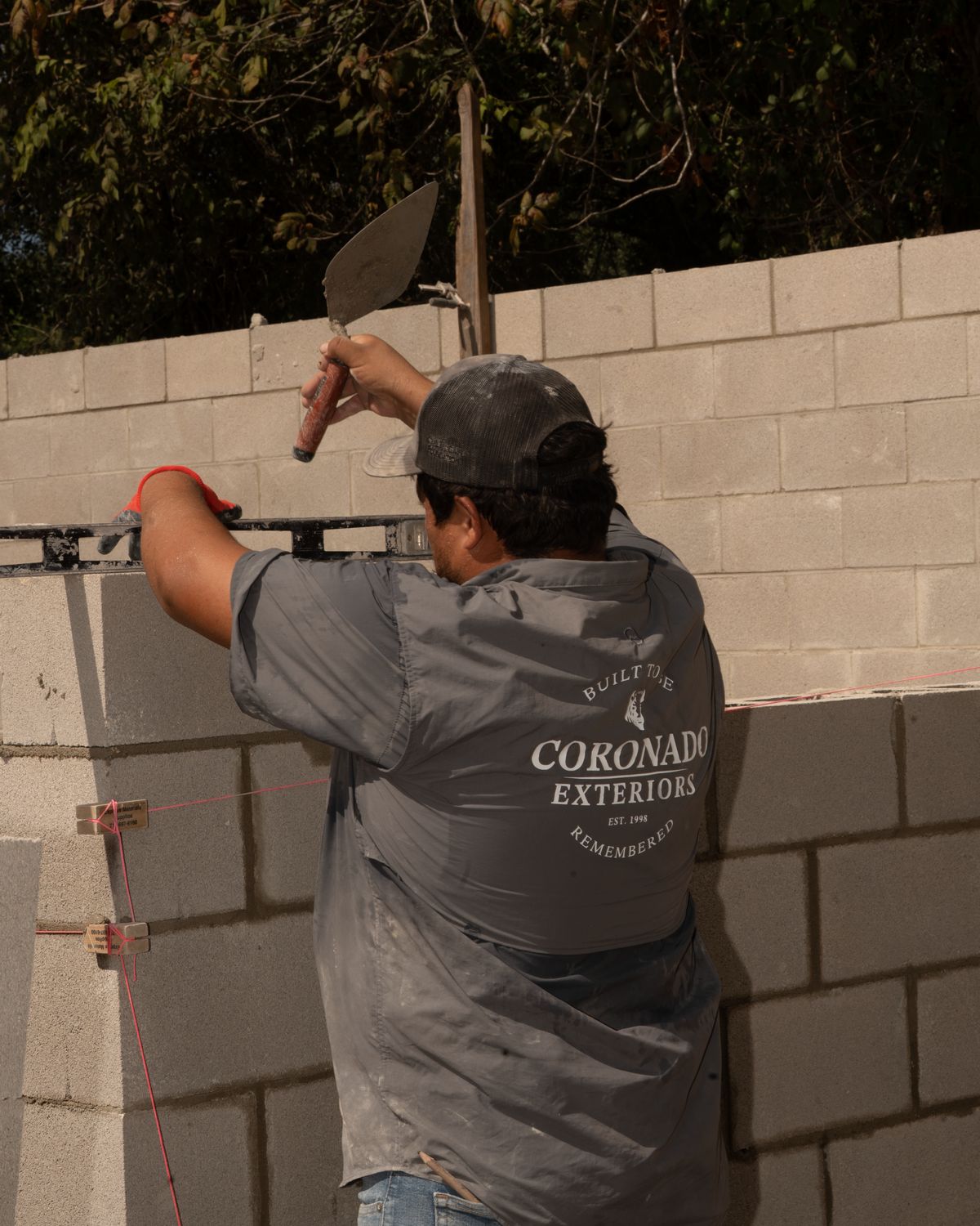 Coronado Exteriors mason leveling a CMU wall