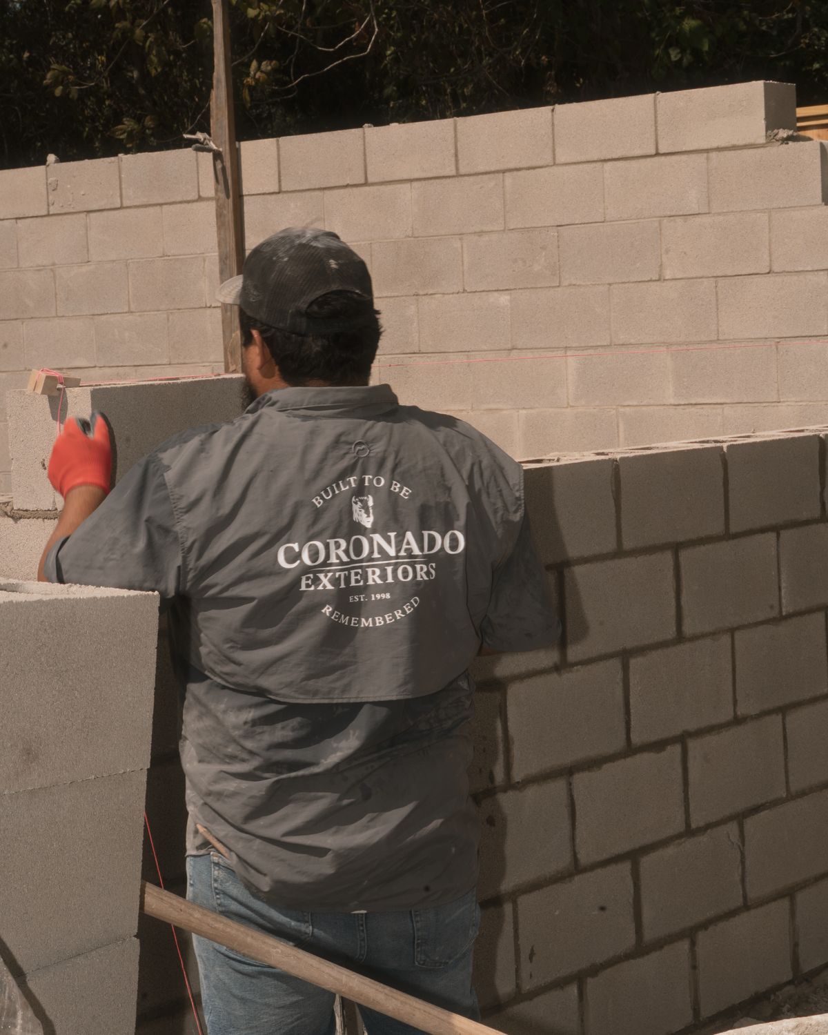 Coronado Exteriors mason setting a CMU block wall to the string line in Houston, TX