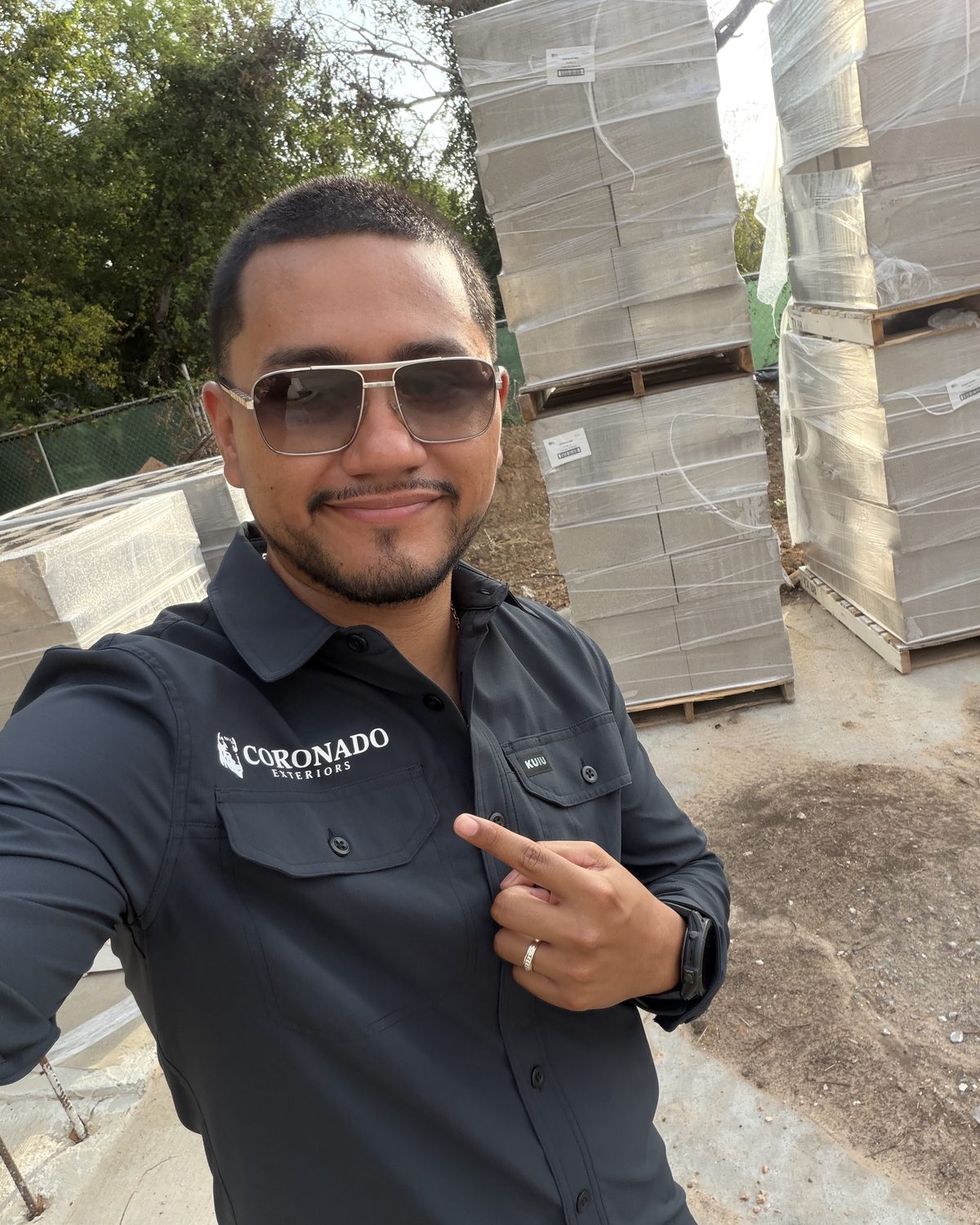 Alejandro Coronado with pallets of CMU concrete block on a Coronado Exteriors jobsite